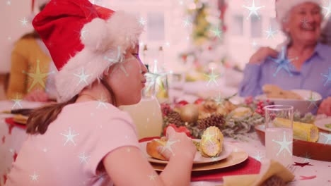 Animation-Von-Schnee,-Der-über-Eine-Lächelnde-Kaukasische-Familie-Mit-Weihnachtsmützen-Beim-Abendessen-Fällt