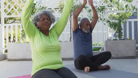 Entspanntes-Afroamerikanisches-Seniorenpaar,-Das-Yoga-Auf-Einer-Matte-Auf-Der-Terrasse-Praktiziert