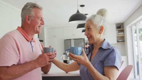 Feliz-Pareja-De-Ancianos-Caucásicos-Con-Café-Hablando-Juntos-En-La-Cocina