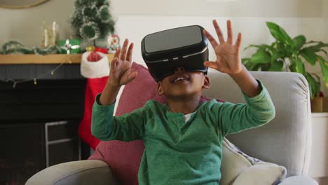 Fröhlicher-Afroamerikanischer-Junge,-Der-Ein-VR-Headset-Trägt-Und-Zur-Weihnachtszeit-Spaß-Hat