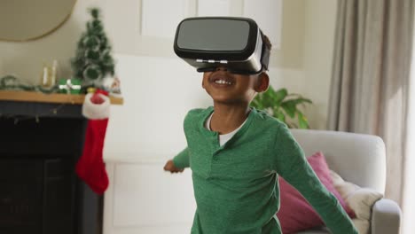 Fröhlicher-Afroamerikanischer-Junge,-Der-Ein-VR-Headset-Trägt-Und-Zur-Weihnachtszeit-Spaß-Hat