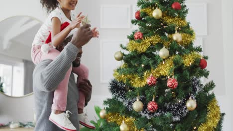 Glücklicher-Afroamerikanischer-Vater-Und-Tochter,-Die-Den-Weihnachtsbaum-Schmücken