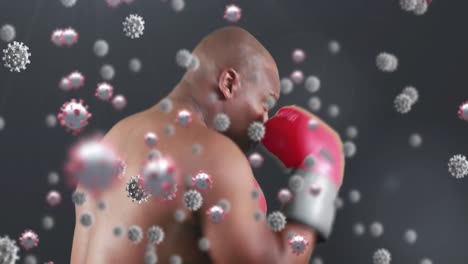 Animation-of-virus-cells-floating-over-african-american-man-boxing