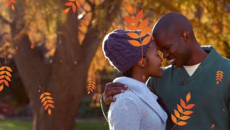 Animation-of-orange-autumn-leaves-falling-over-happy-african-american-couple-in-park