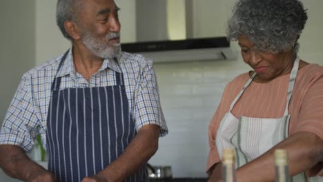 Glückliches-Afroamerikanisches-Seniorenpaar,-Das-Zusammen-Kocht