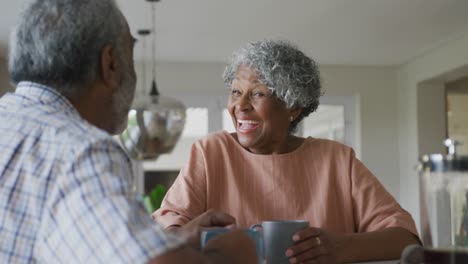 Animation-of-happy-african-american-senior-woman-with-coffee-talking-to-her-male-partner