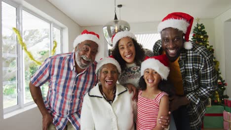 Happy-african-american-multi-generation-family-wearing-santa-hats,-taking-holiday-photo