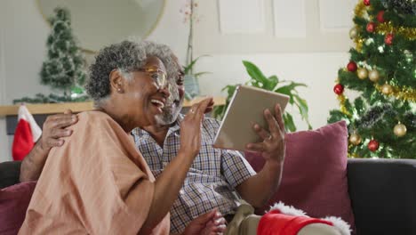Happy-african-american-senior-couple-having-video-call-at-christmas-time