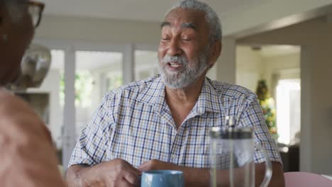 Animation-of-happy-african-american-senior-man-with-coffee-talking-to-his-female-partner