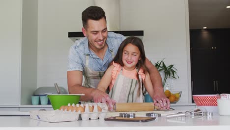 Happy-caucasian-father-and-daughter-baking-together-in-kitchen