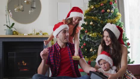 Glückliche-Kaukasische-Familie-Mit-Weihnachtsmützen,-Die-Geschenke-Teilt