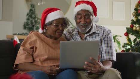 Animation-of-happy-african-american-senior-couple-having-video-call-at-christmas-time
