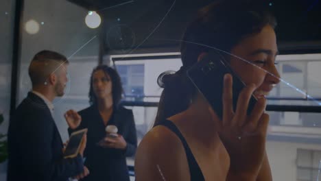 Animation-of-networks-of-connections-over-mixed-race-businesswoman-talking-on-smartphone-in-office