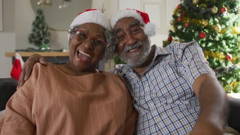 Animation-of-happy-african-american-senior-couple-having-video-call-at-christmas-time