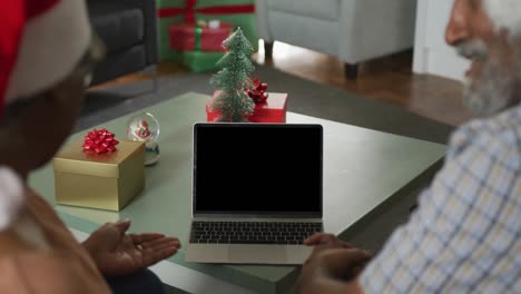 Animation-Eines-Afroamerikanischen-Seniorenpaares,-Das-Zur-Weihnachtszeit-Einen-Laptop-Mit-Kopierplatz-Auf-Dem-Bildschirm-Benutzt