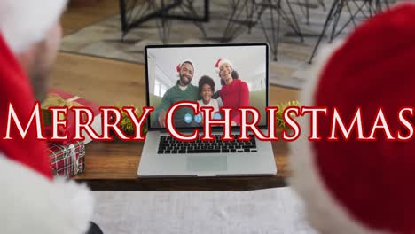 Animation-of-merry-christmas-text-over-caucasian-father-and-son-in-santa-hats-on-laptop-video-call