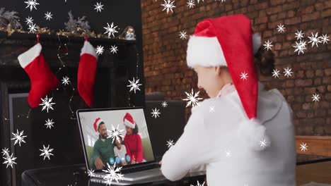 Animation-of-snow-falling-over-caucasian-girl-in-santa-hat-on-laptop-video-call-at-christmas