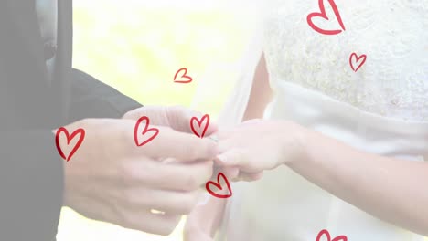 Animation-of-red-hearts-over-caucasian-couple-wearing-rings