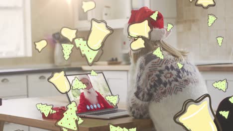 Animation-of-christmas-cookies-over-woman-in-santa-hat-on-laptop-video-call-with-santa-claus