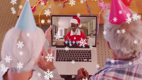 Animation-of-snow-falling-text-over-senior-caucasian-couple-on-laptop-video-call-at-christmas