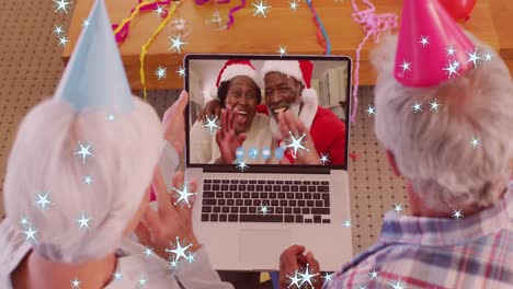 Animation-of-stars-falling-over-senior-caucasian-couple-on-laptop-video-call-at-christmas