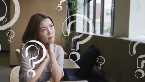 Animation-of-question-marks-over-asian-businesswoman-thinking