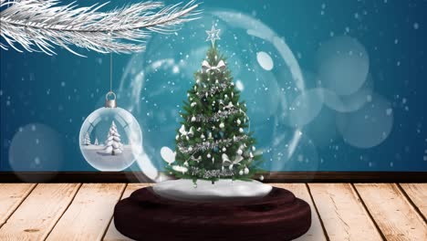 Animation-of-snow-falling-and-glowing-spots-over-snow-globe-with-tree-on-blue-background