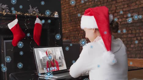 Animation-of-snow-falling-over-smiling-girl-in-santa-hat-making-christmas-video-call-with-family