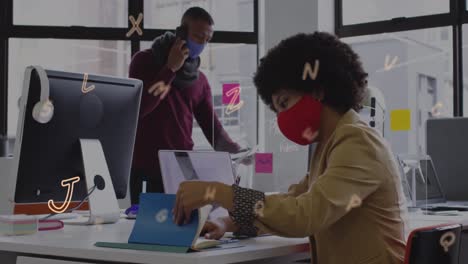 Animation-of-letters-over-diverse-business-people-wearing-face-masks-and-working-in-office
