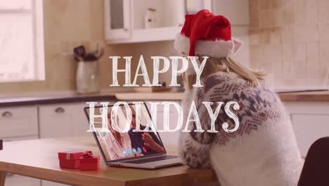 Animation-of-christmas-happy-holidays-text-over-caucasian-woman-in-santa-hat-on-laptop-video-call
