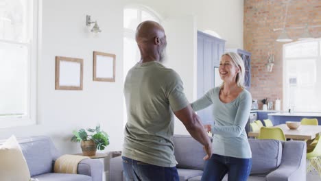 Älteres-Paar-Gemischter-Abstammung-Tanzt-Zusammen-Im-Wohnzimmer-Zu-Hause