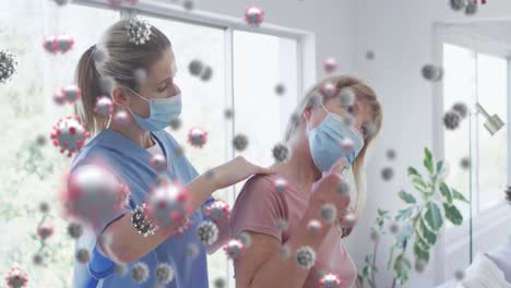 Animation-of-covid-virus-cells-over-caucasian-senior-woman-and-nurse-wearing-face-masks-massaging