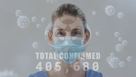 Animation-of-covid-19-virus-cells-and-biohazard-icon-over-caucasian-woman-wearing-face-mask