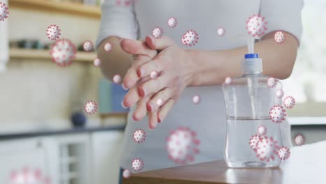 Animation-of-covid-19-virus-cells-over-caucasian-woman-disinfecting-hands