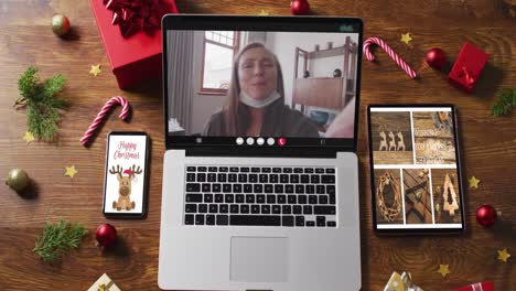 Happy-caucasian-senior-woman-on-video-call,-with-smartphone,-tablet-and-christmas-decorations