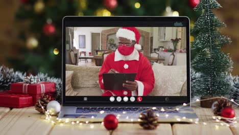 African-american-santa-in-face-mask-on-video-call,-with-christmas-tree