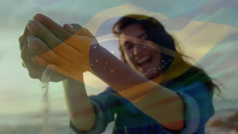 Animation-Der-Wehenden-Brasilianischen-Flagge-über-Einer-Frau,-Die-Spaß-Am-Strand-Hat