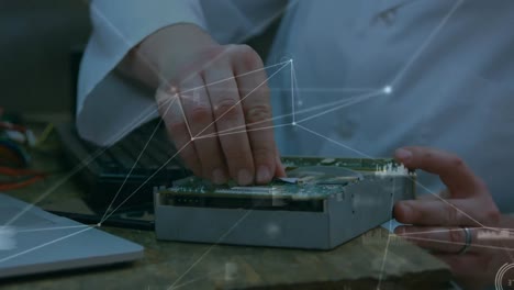 Animation-of-network-of-connections-over-hands-of-caucasian-men-repairing-computer-hardware