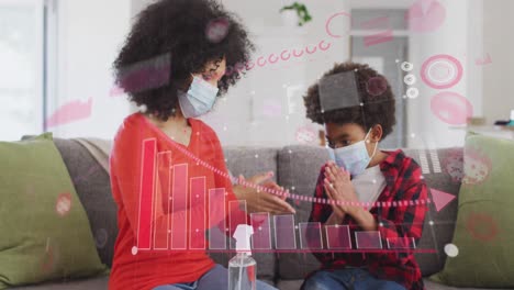 Animation-of-diagram-over-mixed-race-mother-with-son-disinfecting-hands-with-face-masks