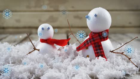 Animation-of-snow-falling-over-snowmen-at-christmas