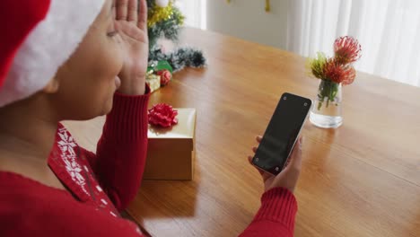 Happy-african-american-plus-size-woman-in-santa-hat,-making-video-call-using-smartphone-at-christmas