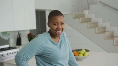 Porträt-Einer-Lächelnden-Afroamerikanischen-Frau-In-Übergröße,-Die-In-Der-Küche-In-Die-Kamera-Blickt