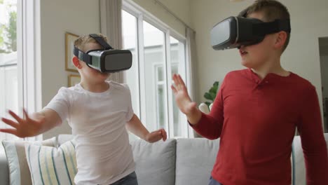 Caucasian-boy-with-brother-using-vr-headsets-and-standing-in-living-room
