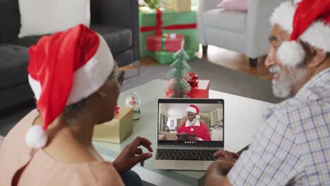 Happy-senior-african-american-couple-on-video-call-with-santa-claus-at-christmas-time