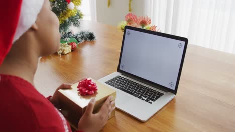 Happy-african-american-plus-size-woman-in-santa-hat,-making-video-call-using-laptop-at-christmas