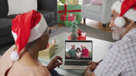 Happy-senior-african-american-couple-on-video-call-on-laptop-with-family-at-christmas-time