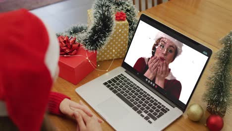 Caucasian-woman-on-video-call-on-laptop-with-female-friend-at-christmas-time