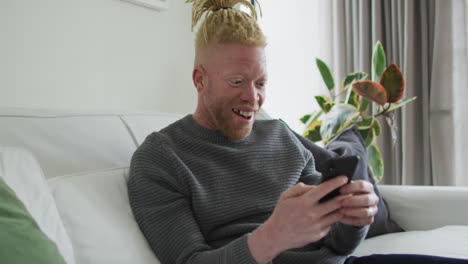 Albino-african-american-man-with-dreadlocks-using-smartphone