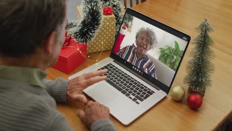 Caucasian-senior-man-on-video-call-on-laptop-with-senior-female-riend-at-christmas-time