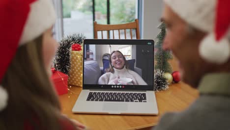 Caucasian-granddaughter-and-grandfather-on-video-call-with-adult-daughter-at-christmas-time